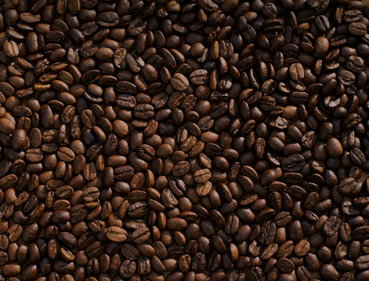 Granos de café en un tazón de madera sobre lino